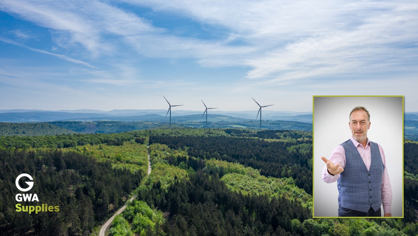 Row of wind turbines on distant heavily wooded hillside with inset, image of Clifford McSpadden
