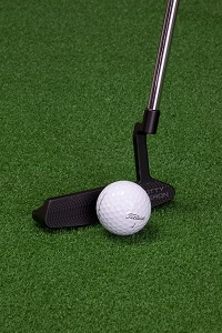 Putter and golf ball and green background