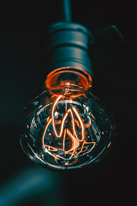 An edison lightbulb is shown illuminated against a black background.