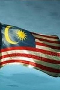 Malaysian Flag blowing in the breeze against a blue sky 