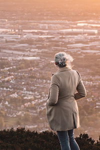 Woman viewing cityscape from mountain top