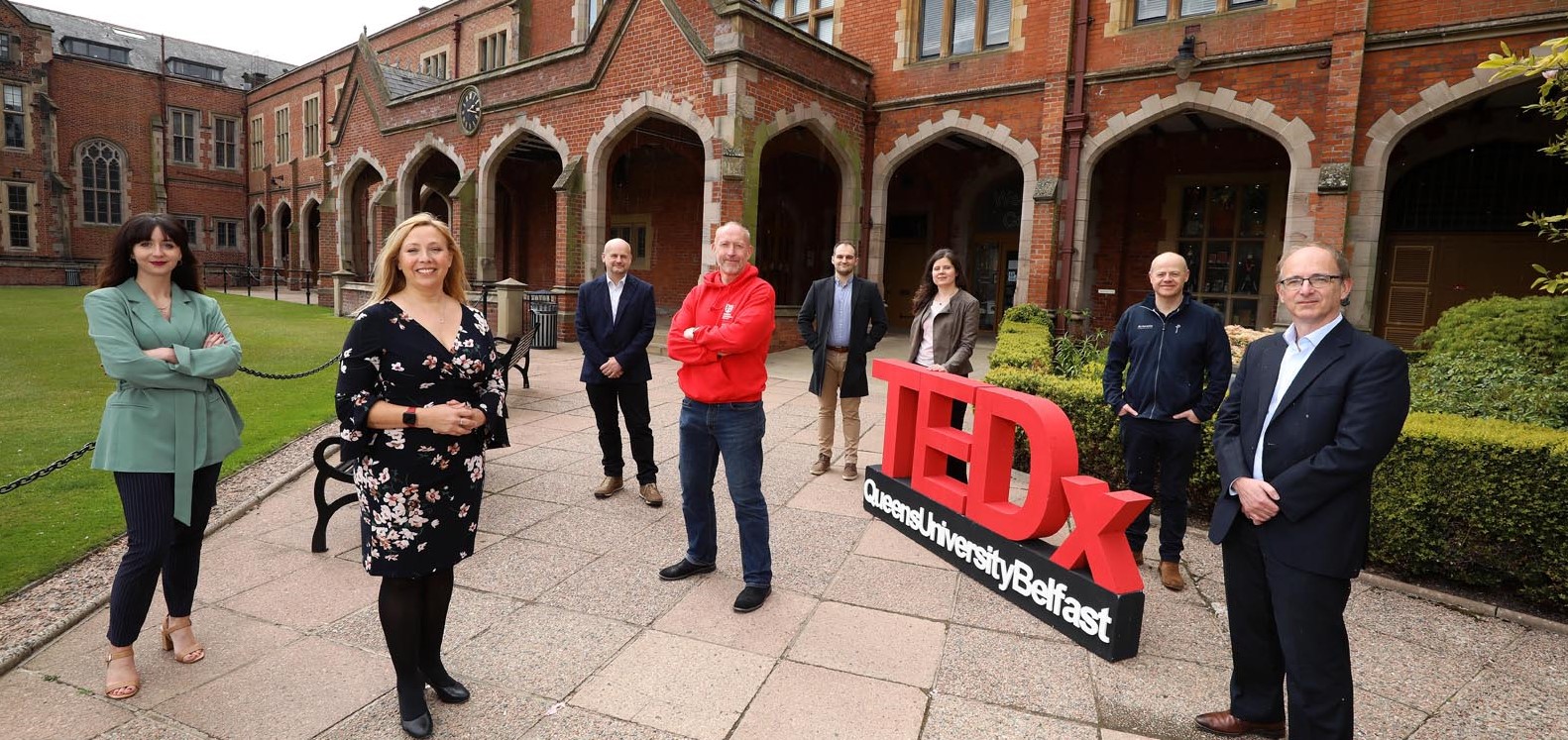Image shows staff and experts in The Quad at Queen's University Belfast with a TEDx sign