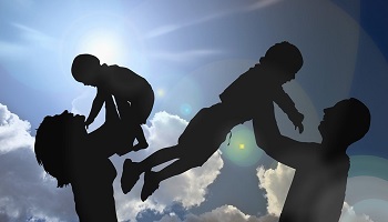 Silhouetted older male and female each holding a child aloft 
