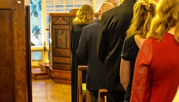 Women and men with backs to camera gathered in church