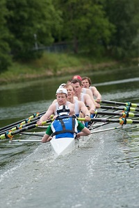 Cox, rowers rowing in a rowing boat on a river 